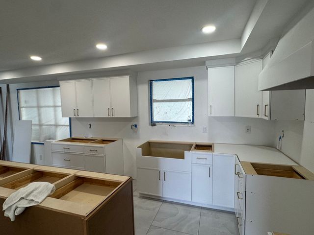 Kitchen with cabinets and island installation in progress.